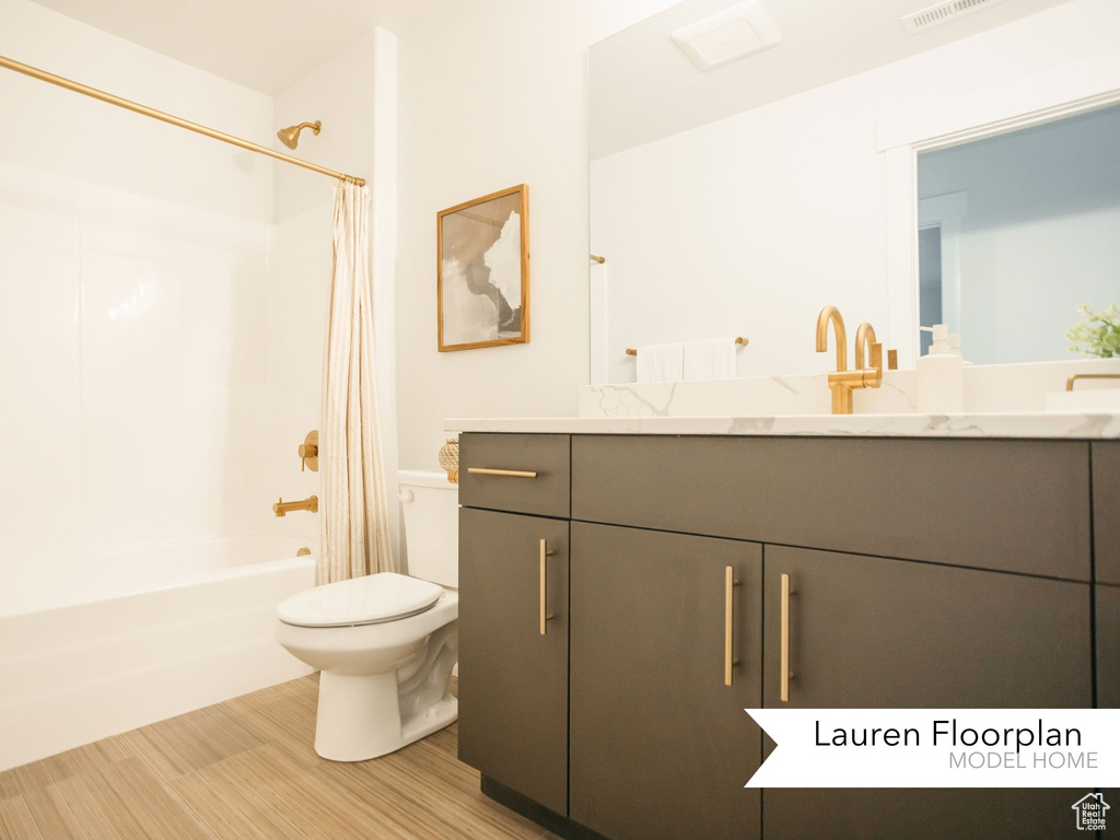 Bathroom with vanity, toilet, shower / bath combo, and wood finished floors
