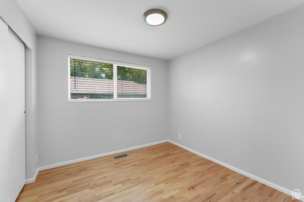 Unfurnished bedroom featuring light wood-style floors, a closet, and baseboards