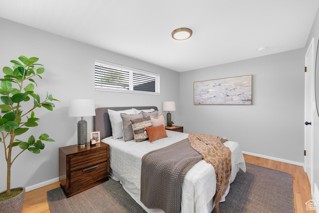 Bedroom with wood finished floors and baseboards