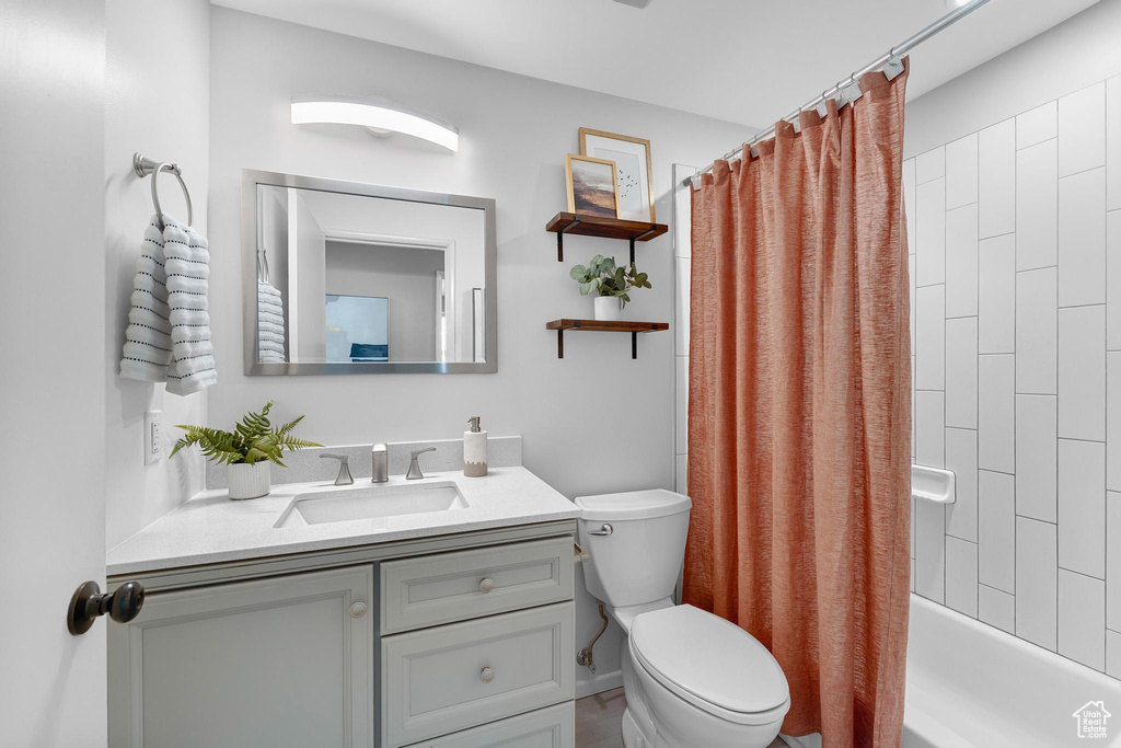 Full bathroom with vanity, toilet, and shower / bathtub combination with curtain