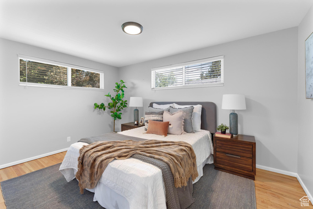 Bedroom with wood finished floors and baseboards