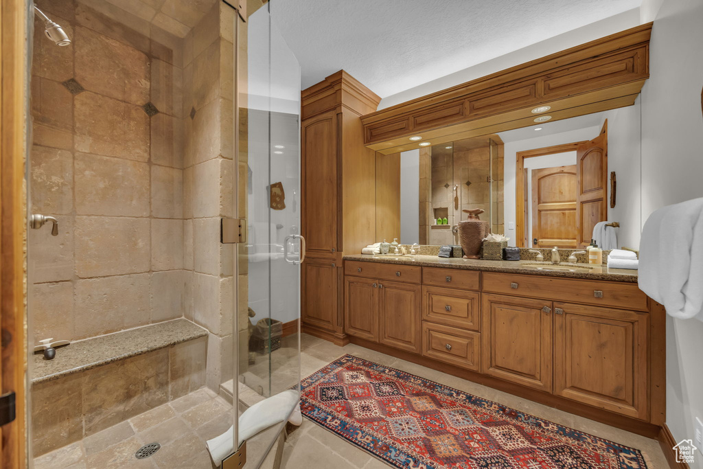 Bathroom featuring a shower stall and double vanity