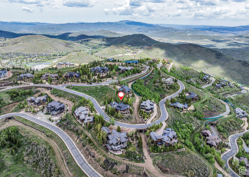 Aerial view of property and surrounding area with a mountainous background and nearby suburban area