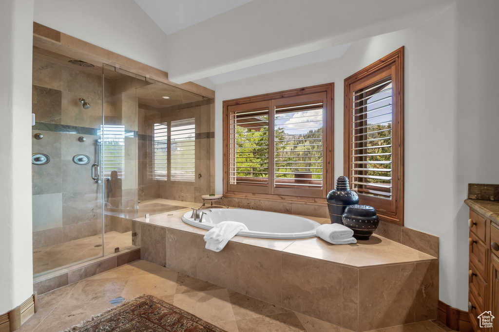 Full bath with a garden tub, vanity, and a stall shower