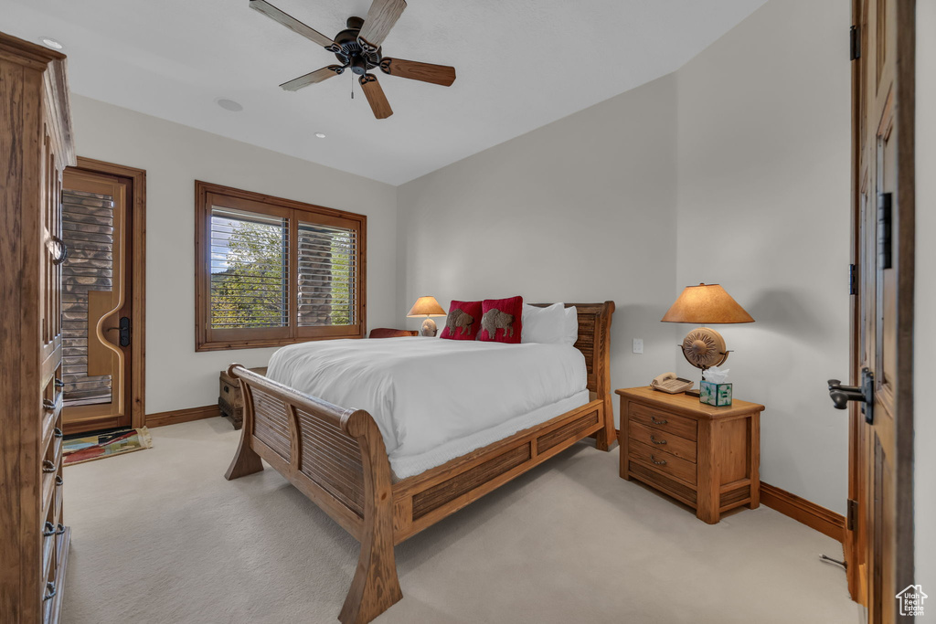 Bedroom with light carpet, baseboards, and a ceiling fan