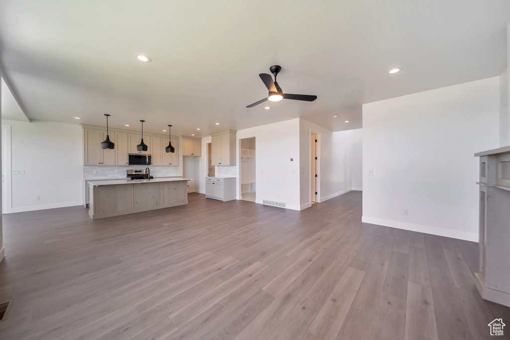 Unfurnished living room featuring recessed lighting, a ceiling fan, baseboards, and dark wood finished floors
