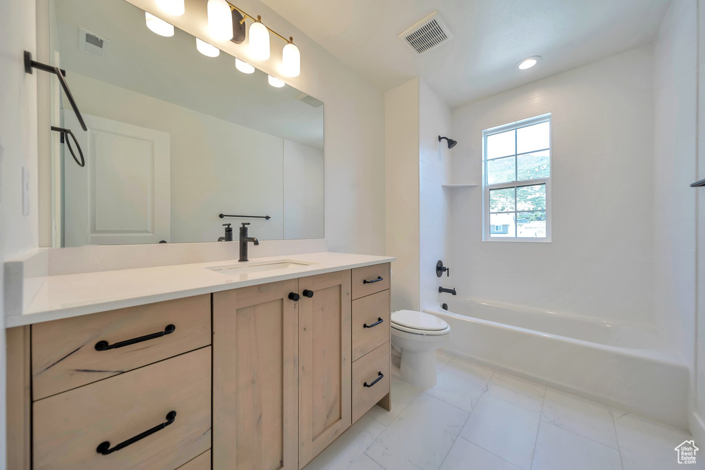 Bathroom featuring vanity, toilet, bathing tub / shower combination, marble finish floors, and recessed lighting