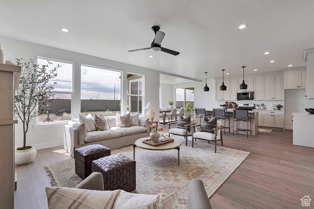 Living room with a ceiling fan, recessed lighting, and wood finished floors