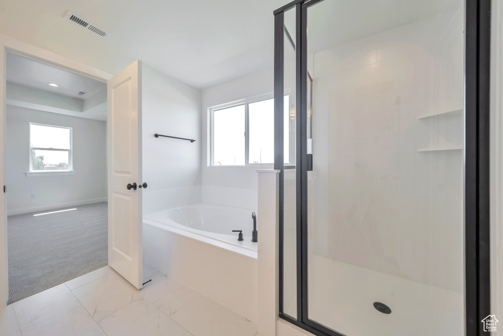Bathroom with a bath, a stall shower, and baseboards