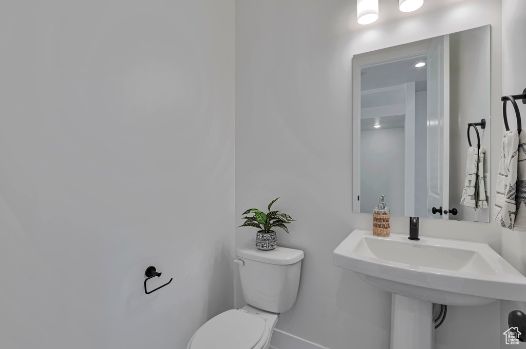 Half bathroom featuring toilet and baseboards