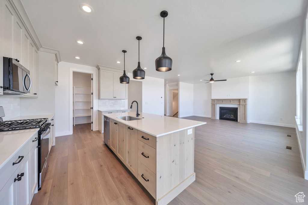 Kitchen with appliances with stainless steel finishes, a sink, recessed lighting, ceiling fan, and baseboards