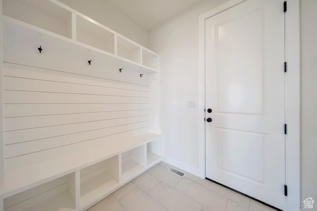 Mudroom with light marble finish floors and baseboards