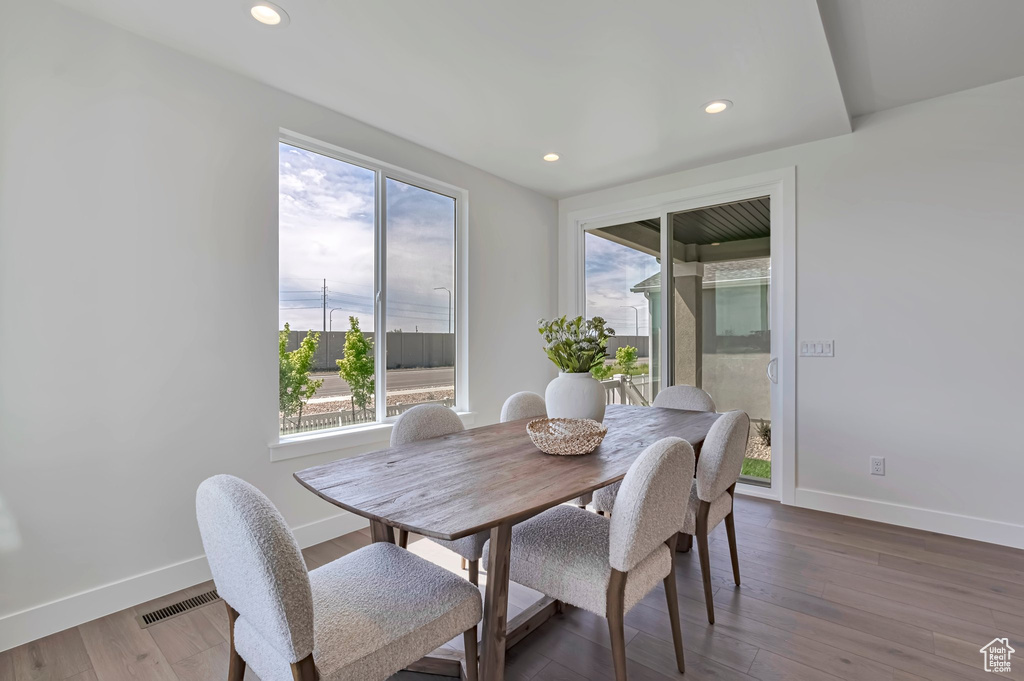 Dining area with healthy amount of natural light, recessed lighting, and wood finished floors