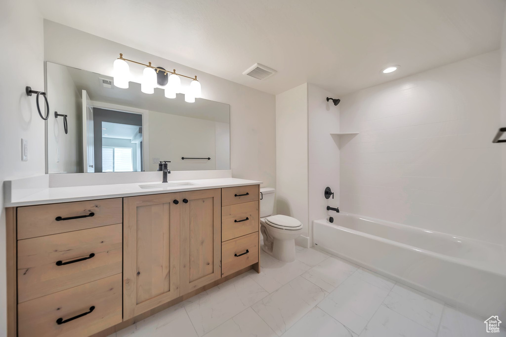 Full bathroom with toilet, vanity, marble look tile flooring, shower / bathtub combination, and recessed lighting