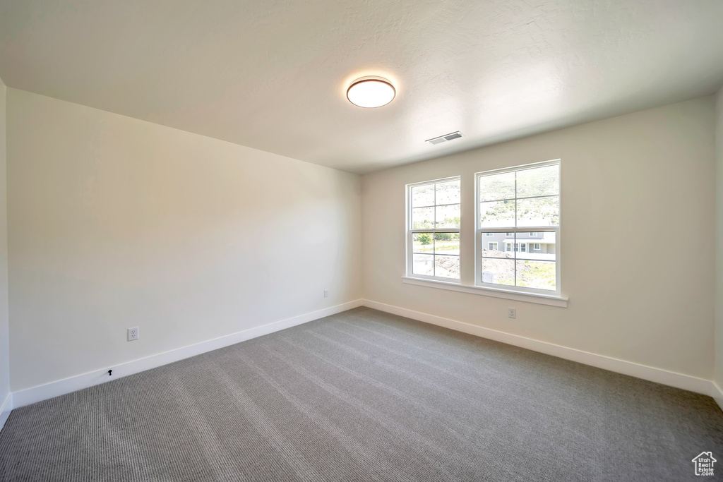 Unfurnished room with baseboards and carpet