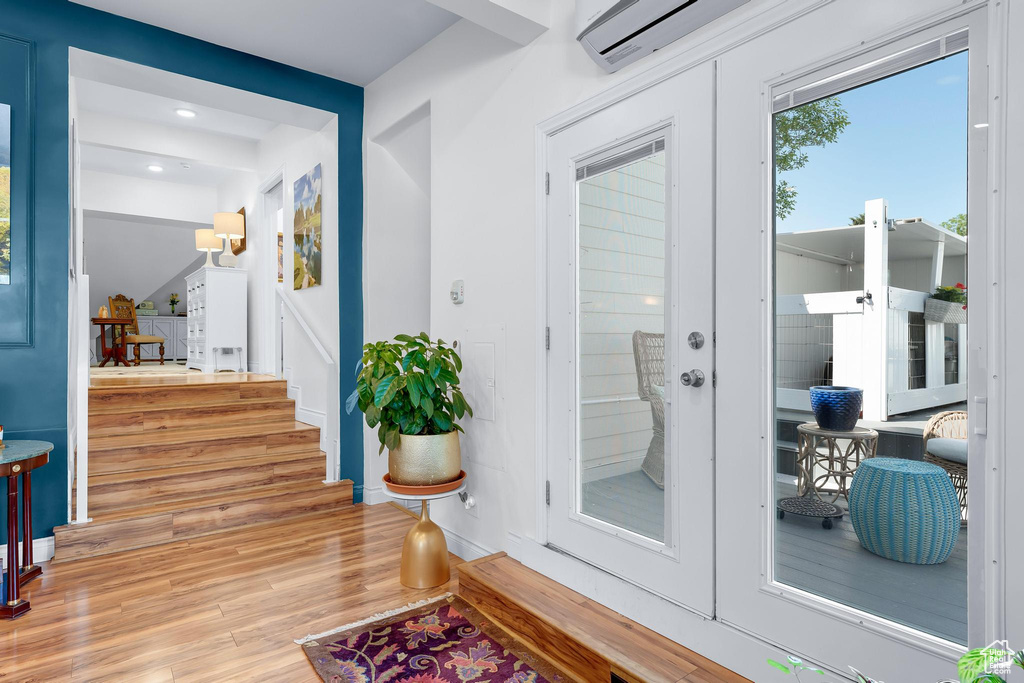 Doorway with wood finished floors, stairway, a wall mounted AC, and recessed lighting