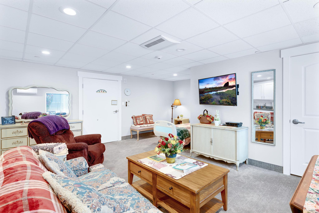 Living area featuring carpet flooring, a drop ceiling, baseboards, and recessed lighting