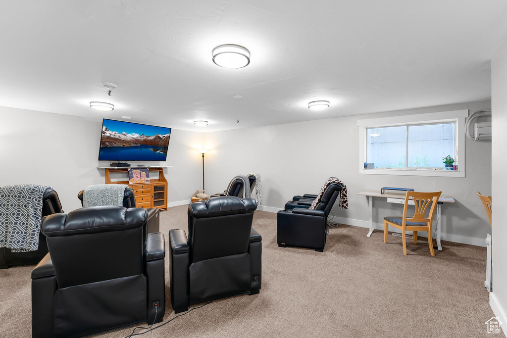 Carpeted home theater room featuring baseboards and an AC wall unit