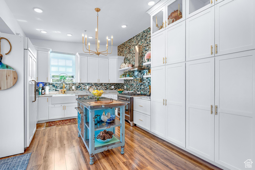 Kitchen featuring high end range, white cabinets, light countertops, a chandelier, and recessed lighting