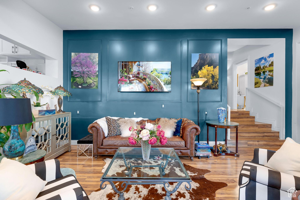 Living area with wood finished floors, recessed lighting, and stairway