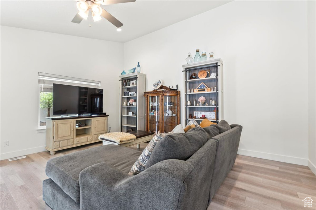 Living area with ceiling fan, light wood-type flooring, and baseboards