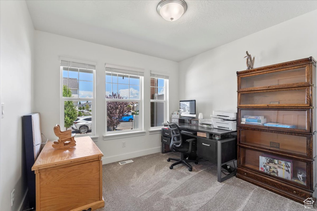 Carpeted home office featuring baseboards