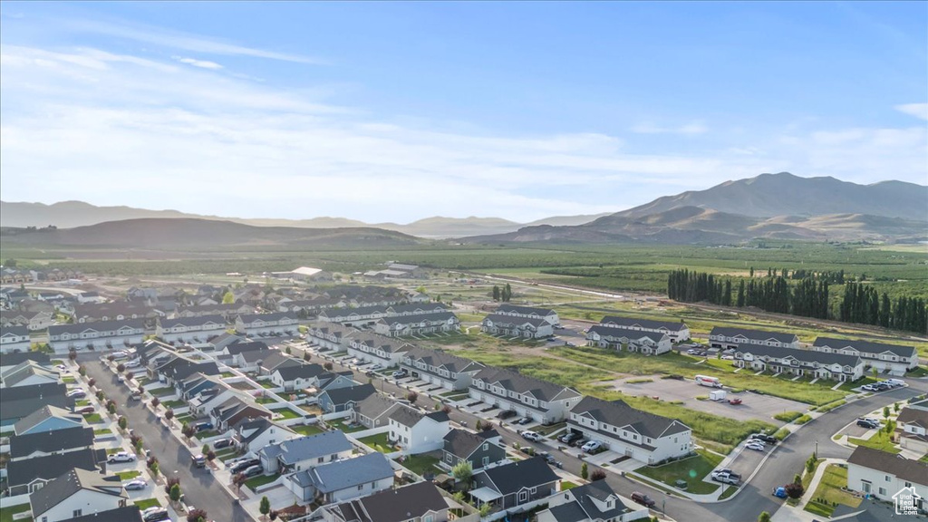 Aerial view of property and surrounding area with a mountain backdrop and nearby suburban area