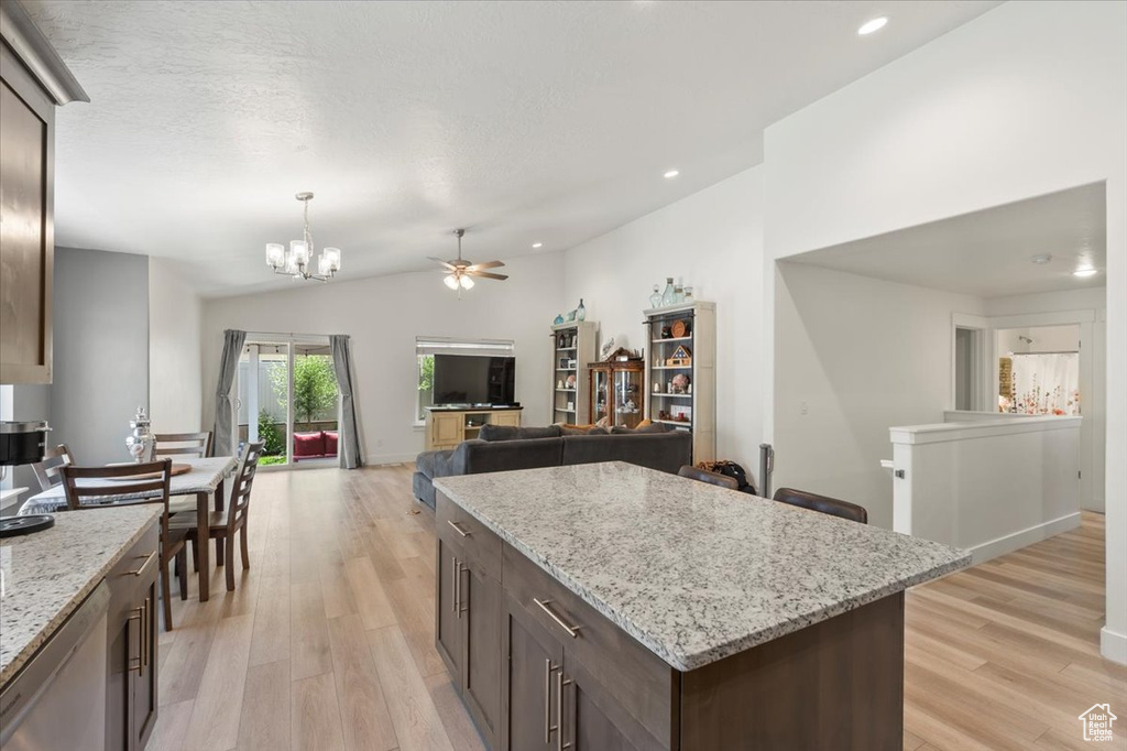 Kitchen featuring vaulted ceiling, a chandelier, light wood-style flooring, ceiling fan, and dark brown cabinetry