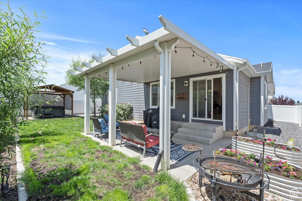 Rear view of house featuring a gazebo, a patio area, an outdoor fire pit, and entry steps
