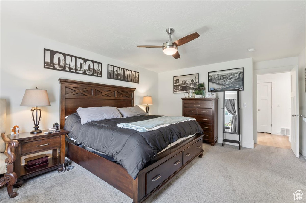 Bedroom featuring light colored carpet and a ceiling fan