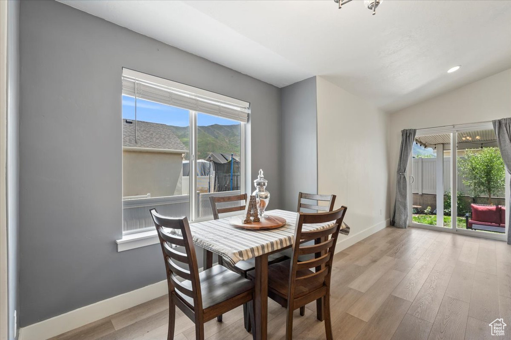 Dining area featuring baseboards, wood finished floors, and vaulted ceiling