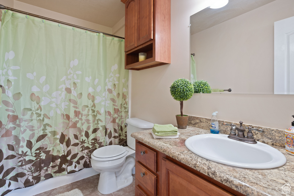 Full bath featuring toilet, vanity, tile patterned flooring, and a shower with shower curtain