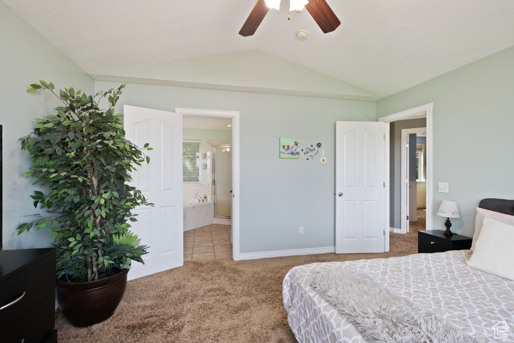 Carpeted bedroom with vaulted ceiling, baseboards, ceiling fan, and connected bathroom