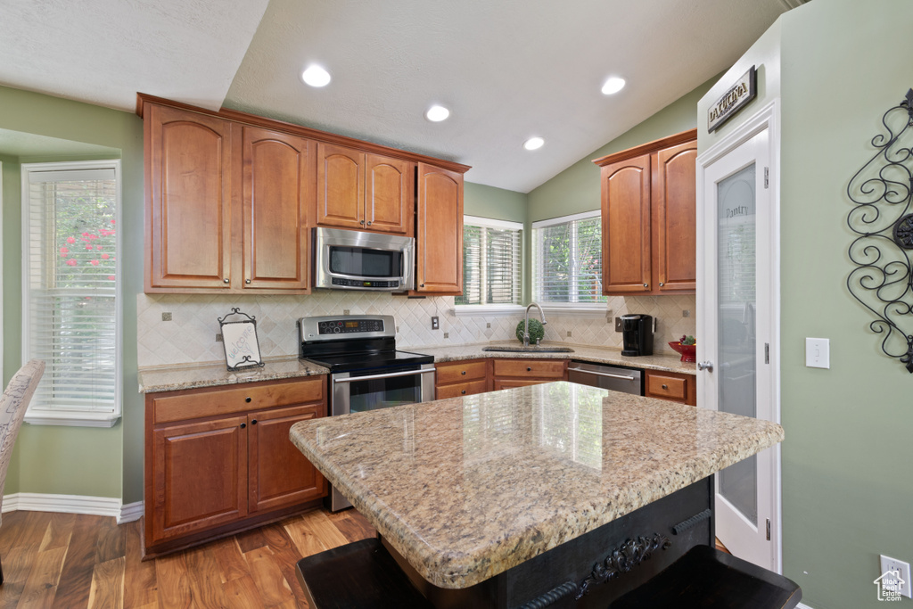 Kitchen featuring stainless steel appliances, a sink, decorative backsplash, light wood-type flooring, and recessed lighting