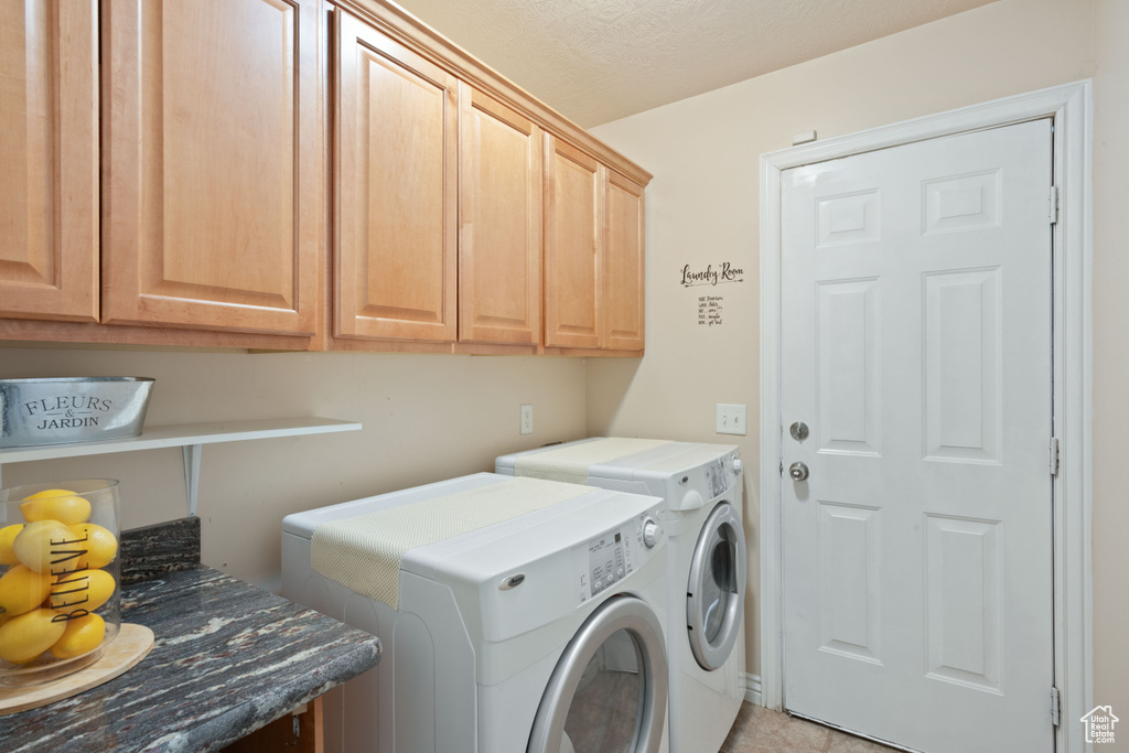 Washroom featuring cabinet space and washing machine and clothes dryer