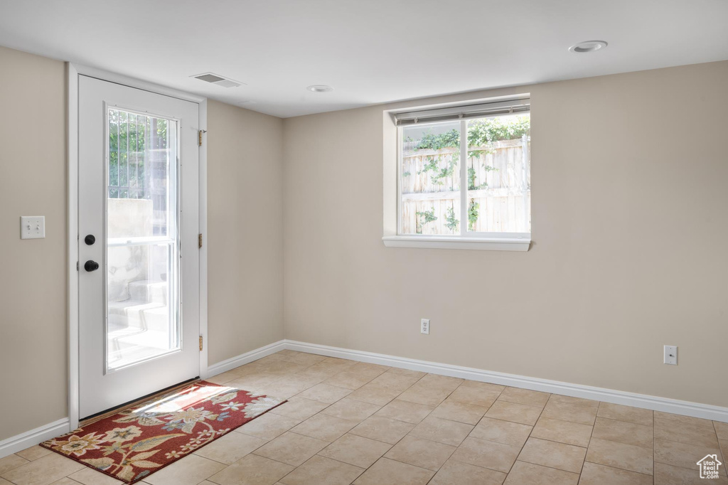Entryway featuring baseboards and light tile patterned floors