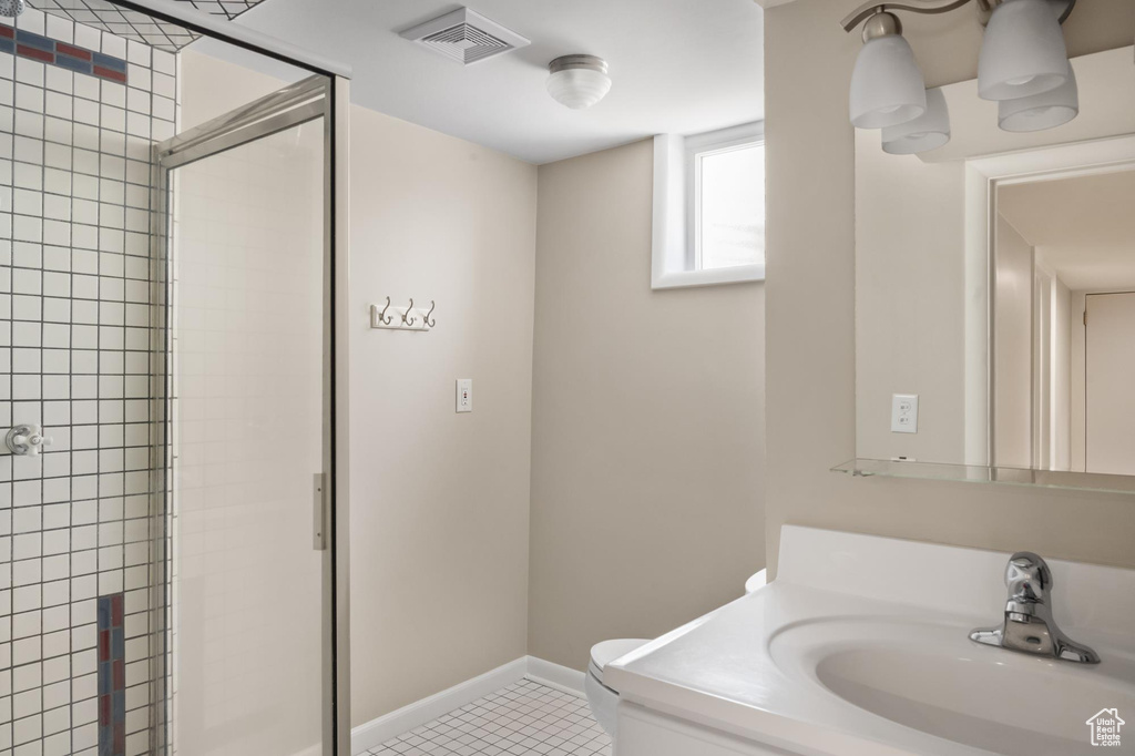 Bathroom featuring toilet, a shower stall, vanity, baseboards, and tile patterned floors