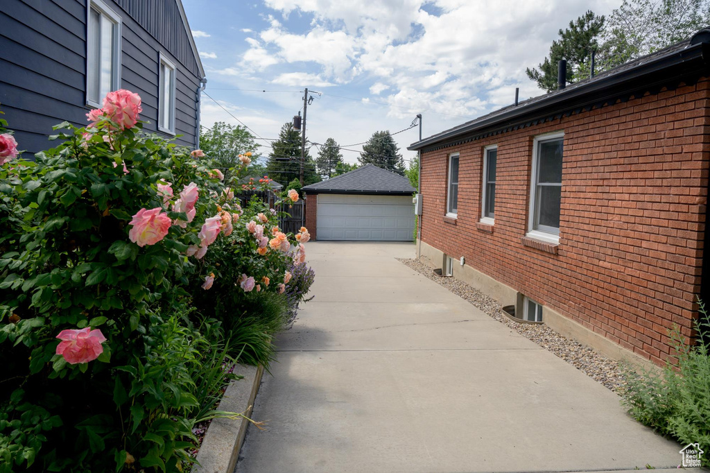 View of home\\\'s exterior featuring brick siding, a garage, and an outdoor structure