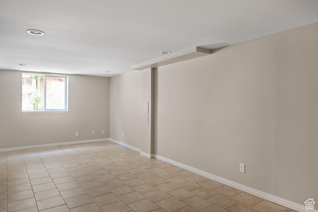 Spare room featuring baseboards, light tile patterned floors, and recessed lighting