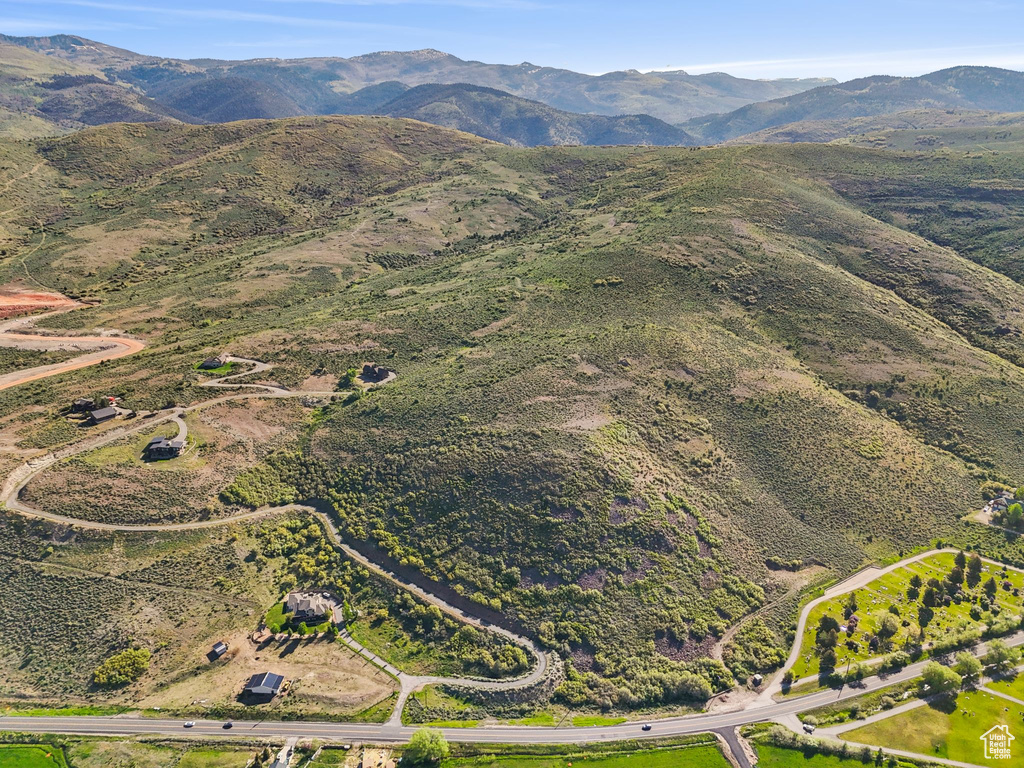 Aerial view of property and surrounding area featuring a mountainous background
