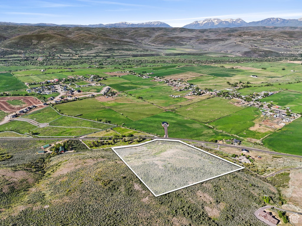 Aerial view of property and surrounding area with property boundaries highlighted and a mountain backdrop
