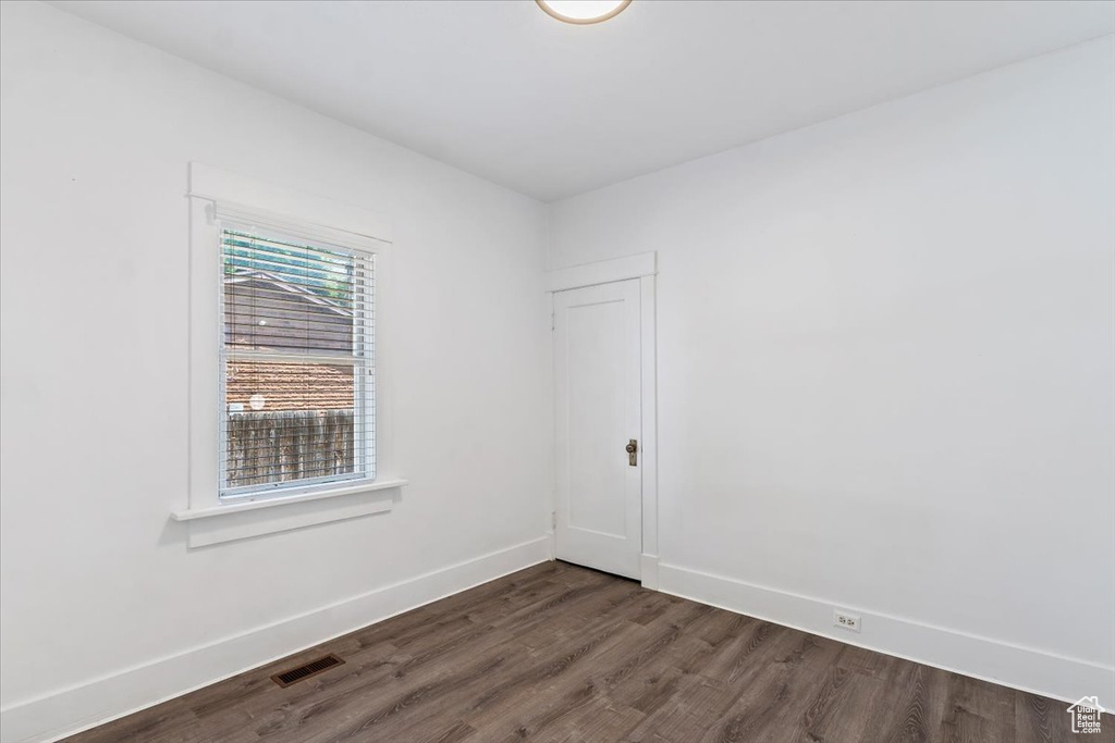 Spare room with dark wood finished floors and baseboards