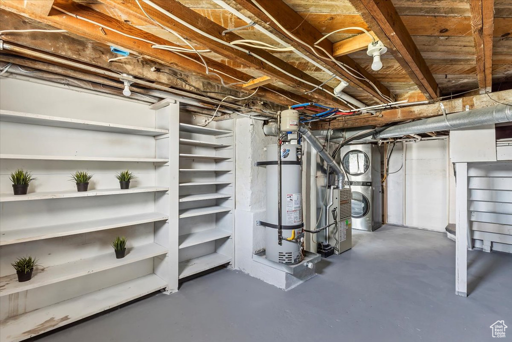 Unfinished basement featuring water heater and washer / clothes dryer