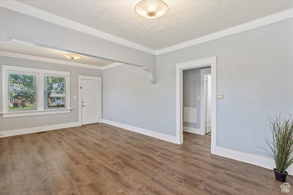 Spare room featuring a textured ceiling, wood finished floors, and baseboards