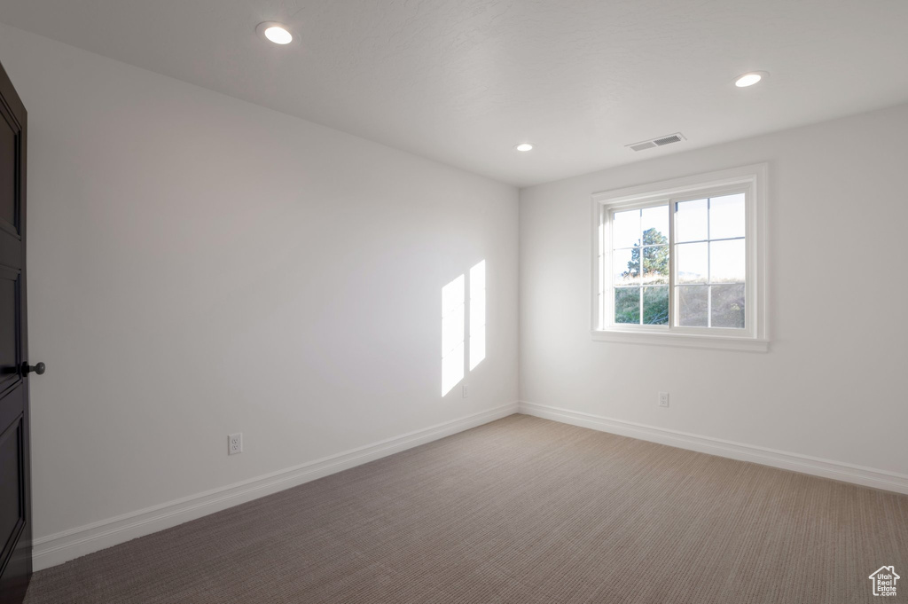 Spare room with recessed lighting, baseboards, and light colored carpet