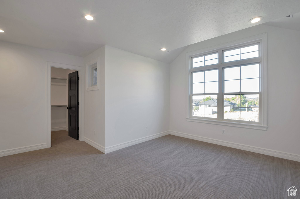 Carpeted empty room with recessed lighting, baseboards, and vaulted ceiling
