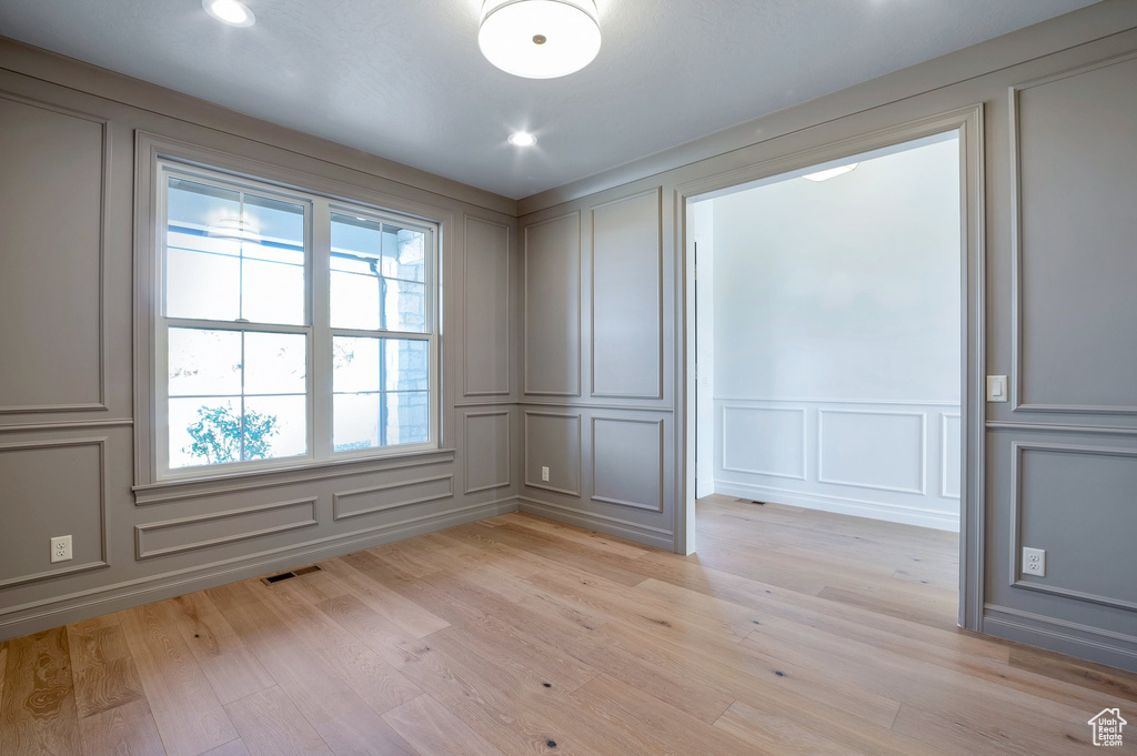 Spare room with a decorative wall, light wood-style floors, and recessed lighting
