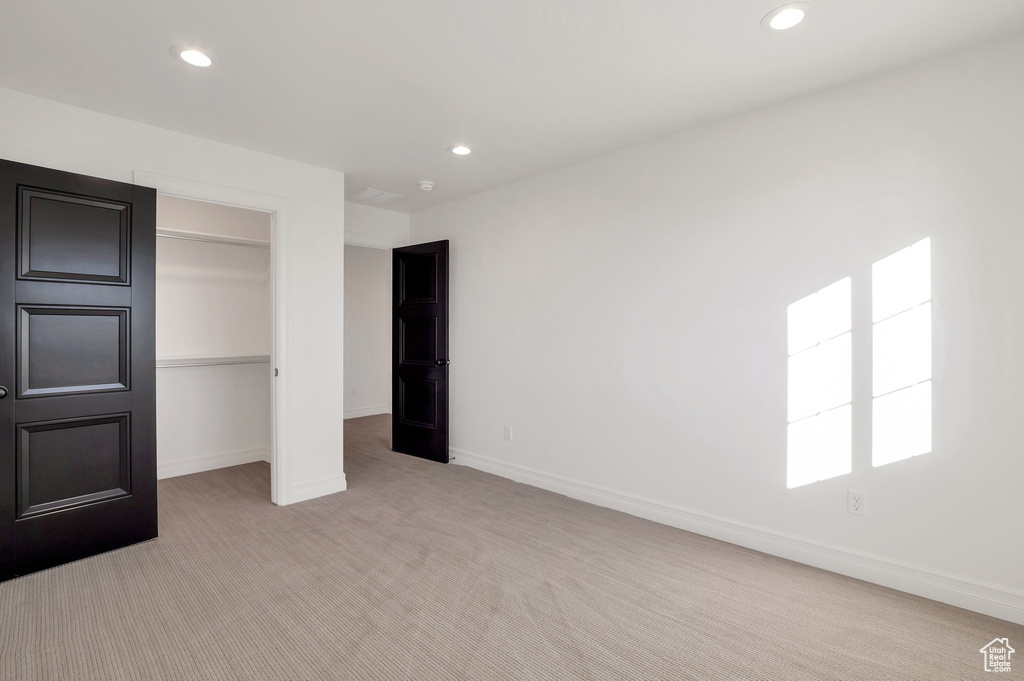 Unfurnished bedroom with light colored carpet, recessed lighting, baseboards, and a closet
