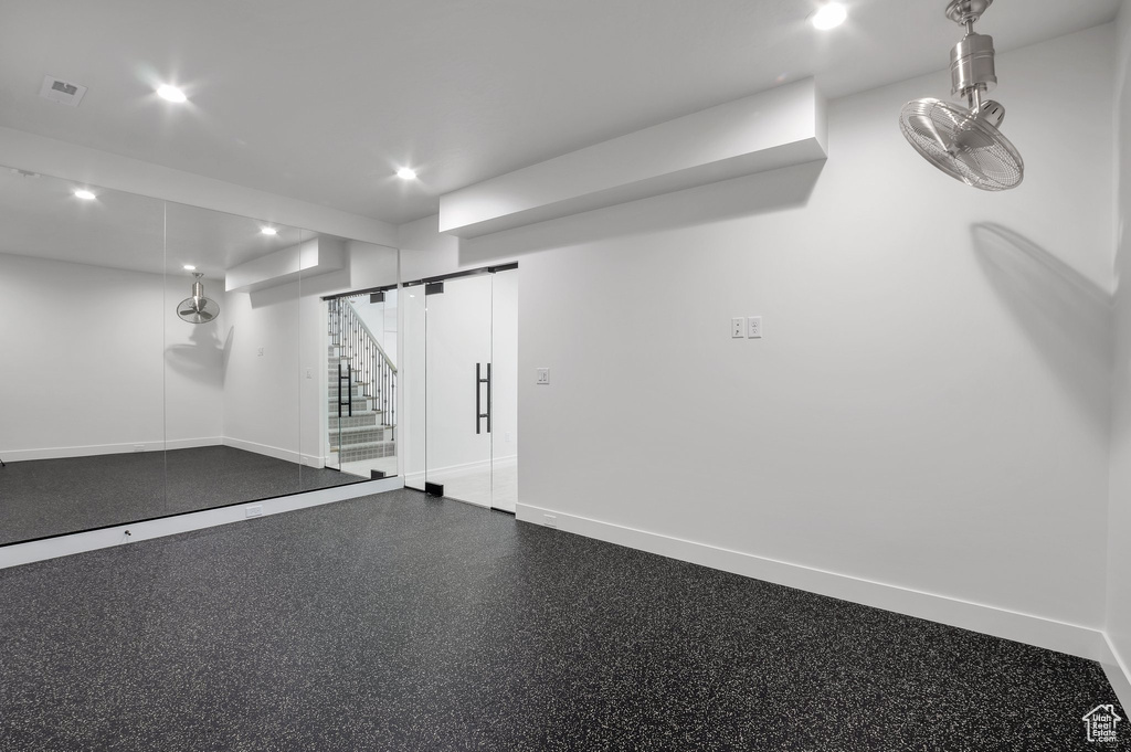 Finished basement featuring baseboards, recessed lighting, and stairway