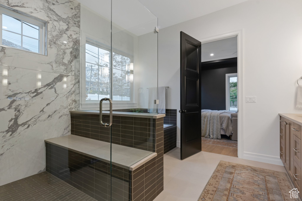 Ensuite bathroom featuring vanity, a shower stall, and plenty of natural light
